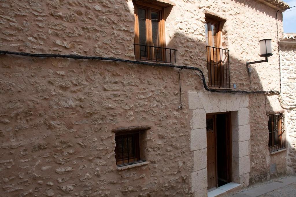 ボカイレントにあるCasa Rural La Llar de Lauraの窓とバルコニー付きの石造りの建物