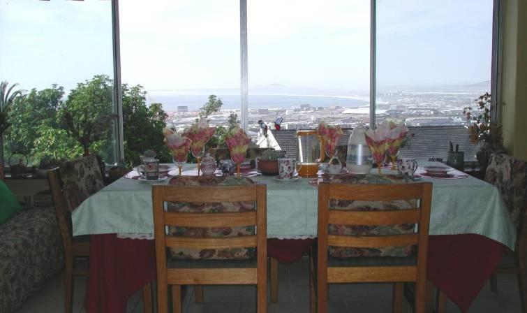 a dining room table with a view of the city at Rachel's Home From Home in Cape Town