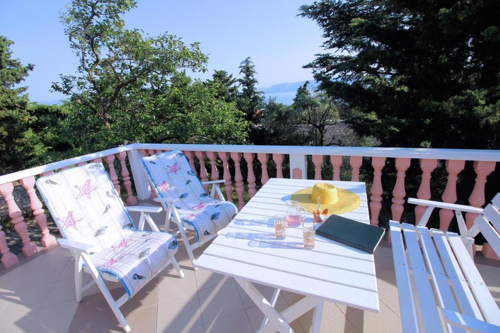 einen weißen Tisch und zwei Stühle auf dem Balkon in der Unterkunft House Barbara in Novi Vinodolski