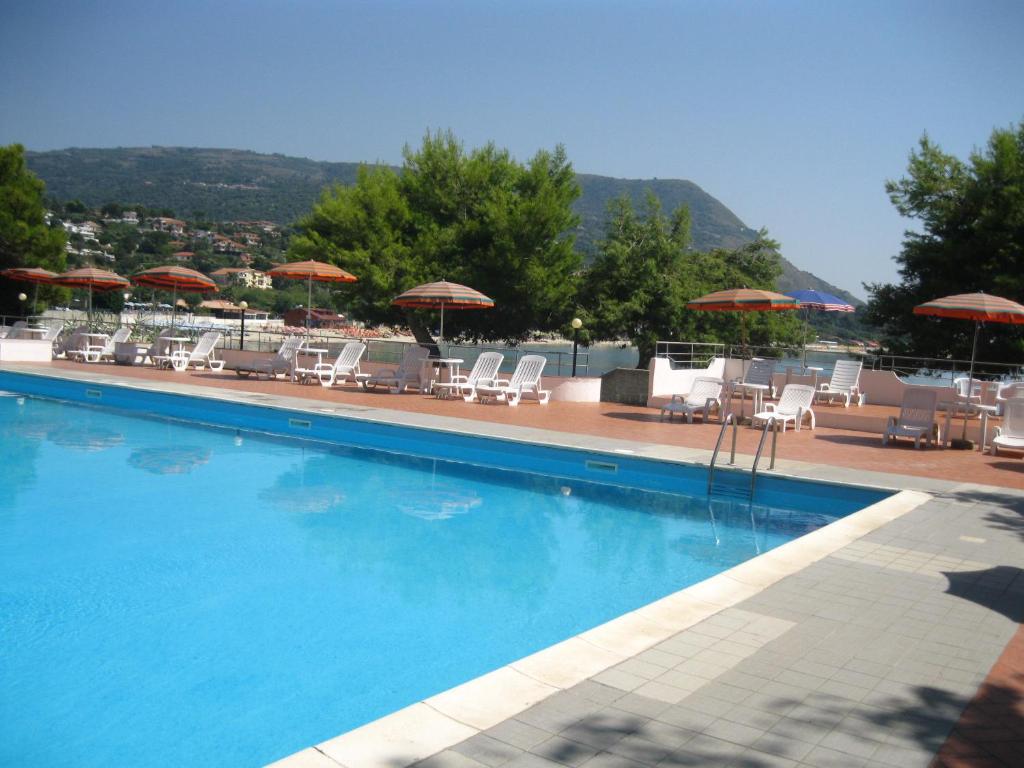 ein großer Pool mit Stühlen und Sonnenschirmen in der Unterkunft Villaggio Marina Del Capo Capo Vaticano in Ricadi