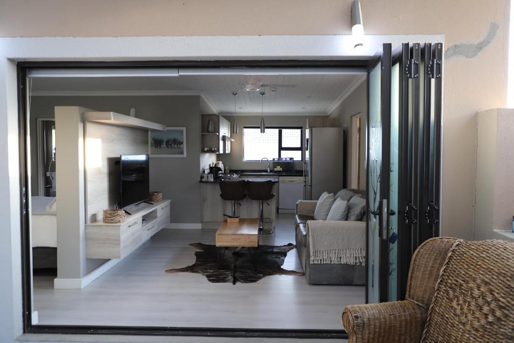 a living room with a sliding glass door leading to a kitchen at Memories Made Cottage in Kampersrus AH