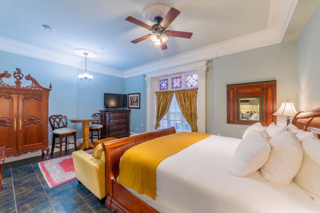 Chipman Hill Suites - Pratt House في سانت جون: غرفة نوم بسرير كبير مع مروحة سقف