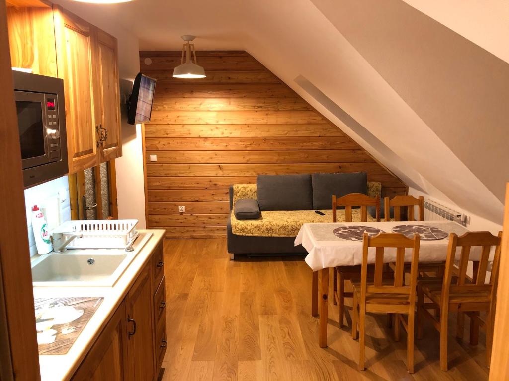 kuchnia z kanapą i stołem w pokoju w obiekcie Apartamenty pokoje Nad Potokiem w Zakopanem