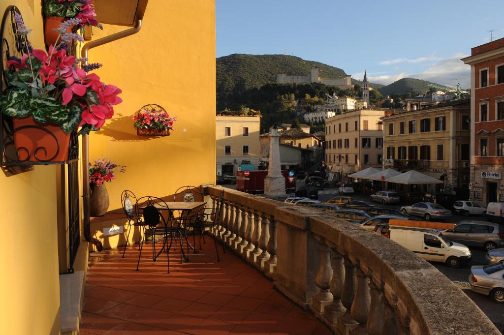 uma varanda com uma mesa e vista para a cidade em La Terrazza em Spoleto
