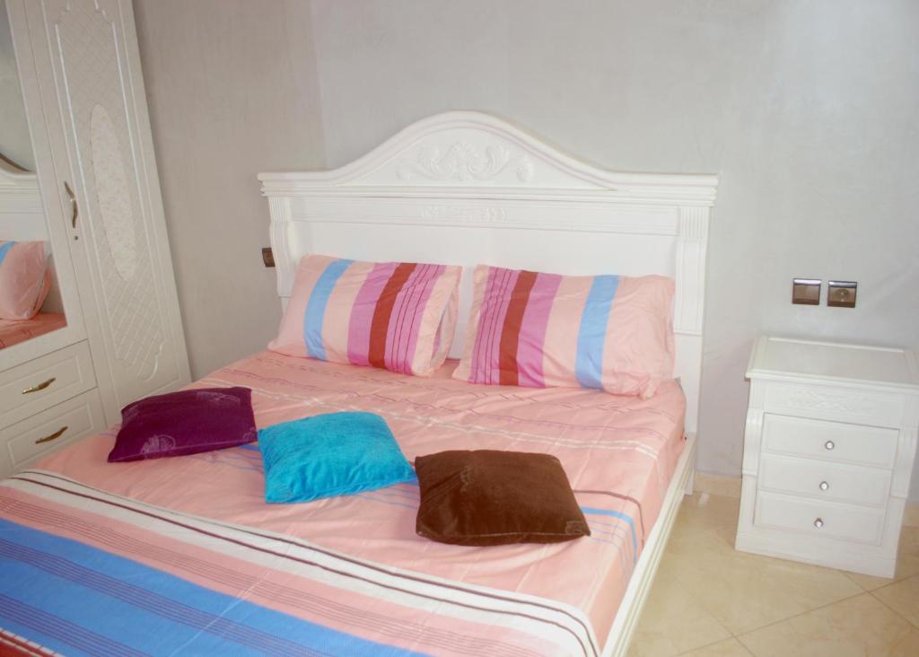 a bed with two bags sitting on top of it at Full Appart Hôtel in Kenitra