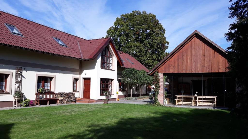 uma casa com um relvado verde em frente em Penzion U Kováře em Kutná Hora