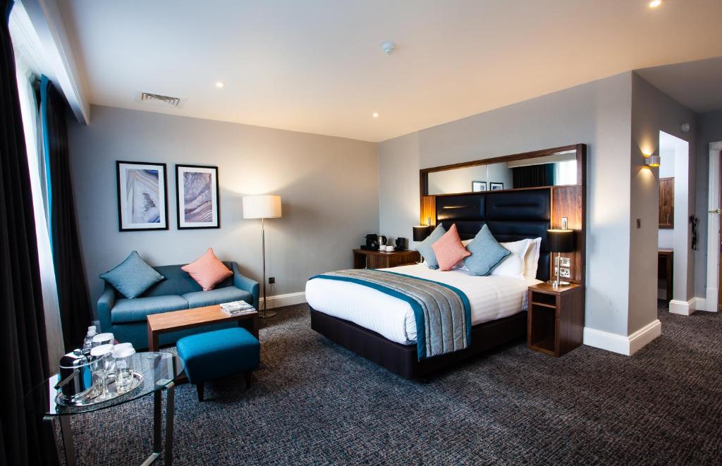 a hotel room with a bed and a blue couch at Crowne Plaza Leeds, an IHG Hotel in Leeds