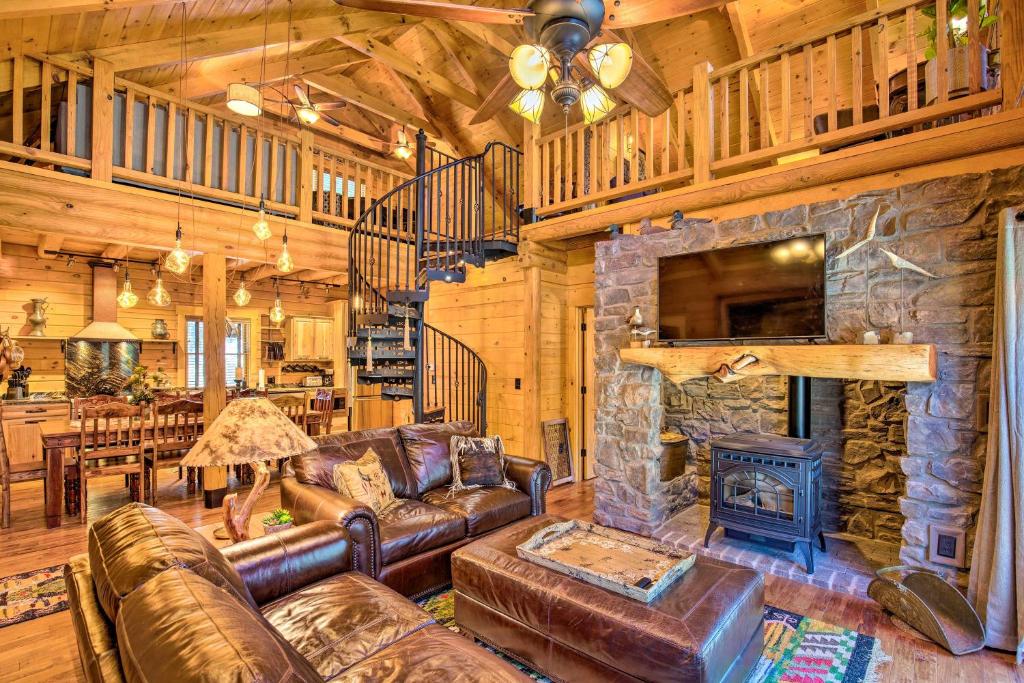 a living room with a couch and a stone fireplace at Luxury Mountain Cabin with Furnished Deck and Views! in Loma Linda