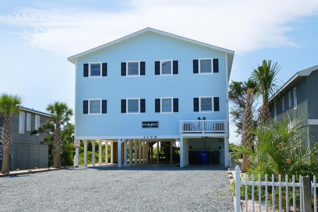 een groot wit huis met een hek ervoor bij Dune Deck South - Duplex in Holden Beach