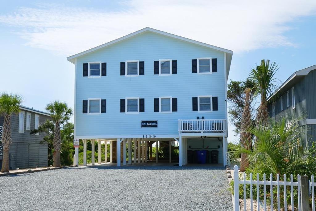a large white house with a fence in front of it at Dune Deck South - Duplex in Holden Beach