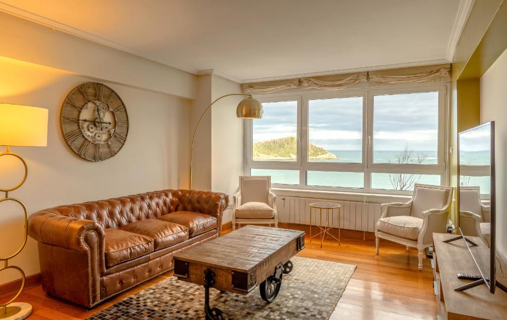 サン・セバスティアンにあるMaskortxo - Basque Stayの革張りのソファとテーブルのあるリビングルーム