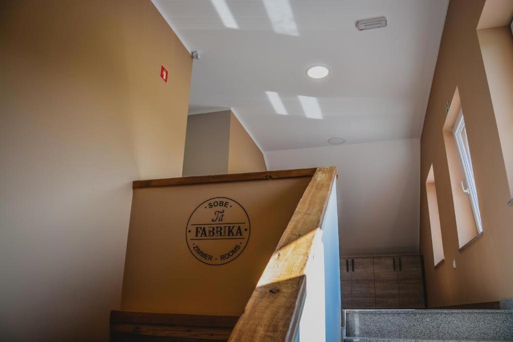 una escalera con una señal en la pared de un edificio en Ta Fabrika Restavracija,pizzerija in prenočišča en Dravograd