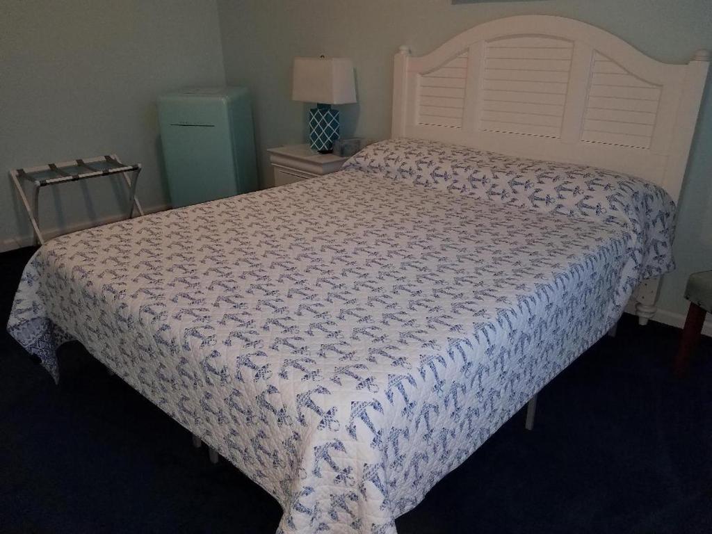 a bedroom with a large bed with a white comforter at Mayfair Hotel in Belmar