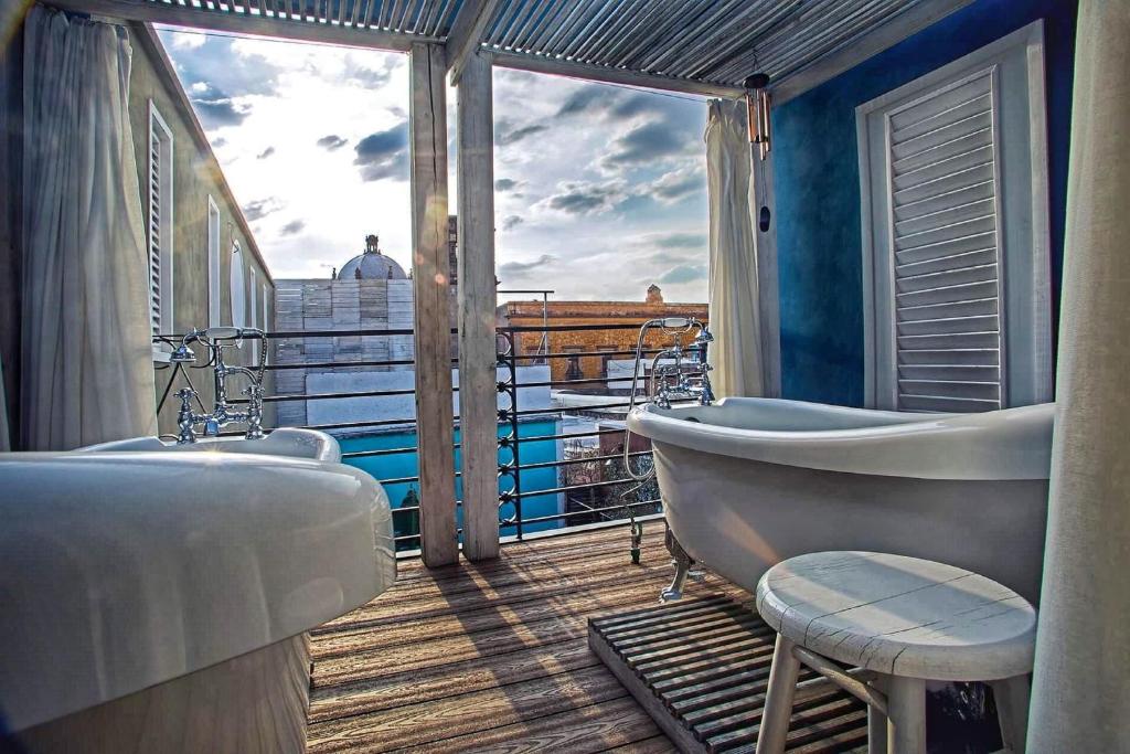 een badkamer met 2 wastafels en een bad op een balkon bij La Casa del Atrio in Querétaro