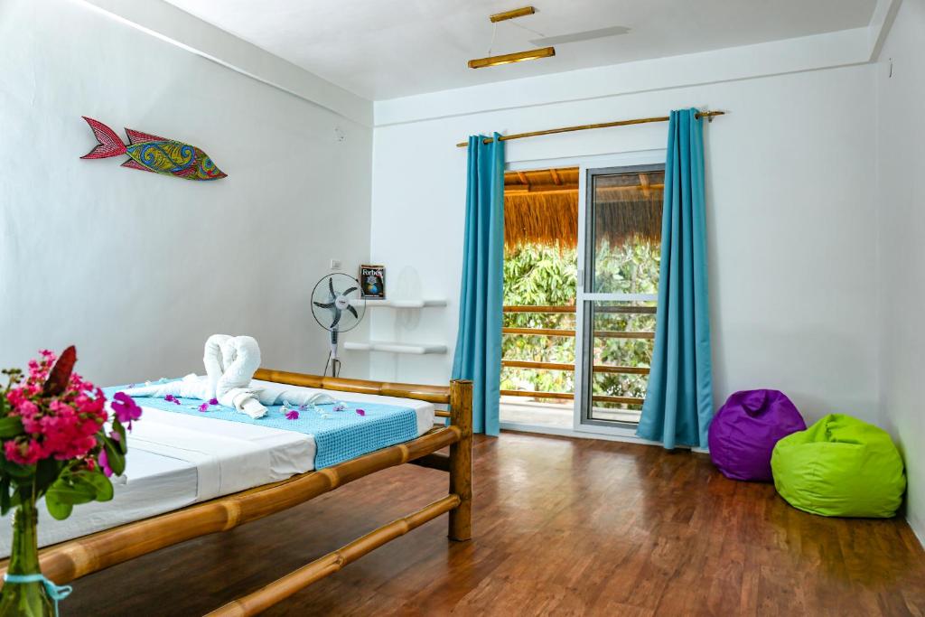 Schlafzimmer mit einem Bett mit blauen Vorhängen und einem Fenster in der Unterkunft Lunazul Guesthouse in San Vicente