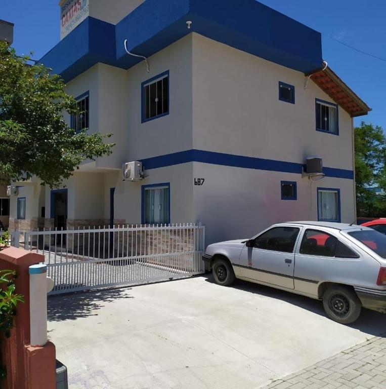 un coche blanco estacionado frente a una casa en Residencial Caxias, en Bombinhas