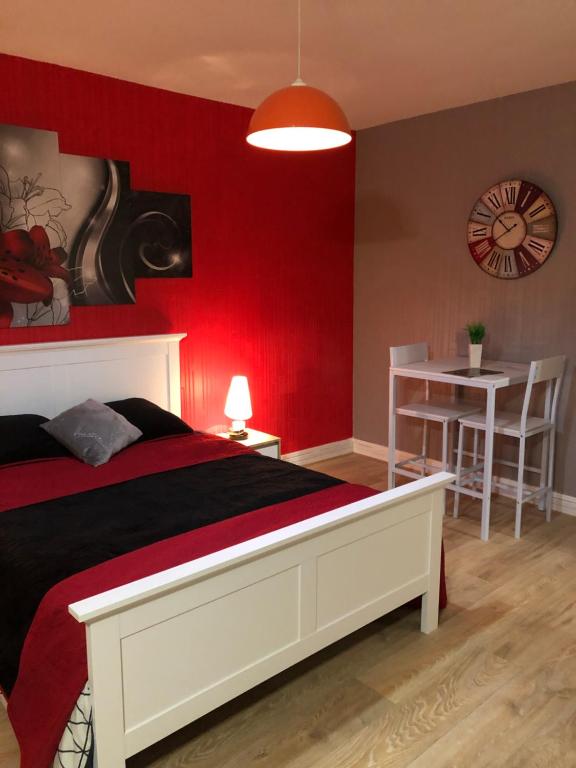 a bedroom with a bed and a red wall at Chambres privées Calais Ferry-Port-Place d&#39;armes in Calais