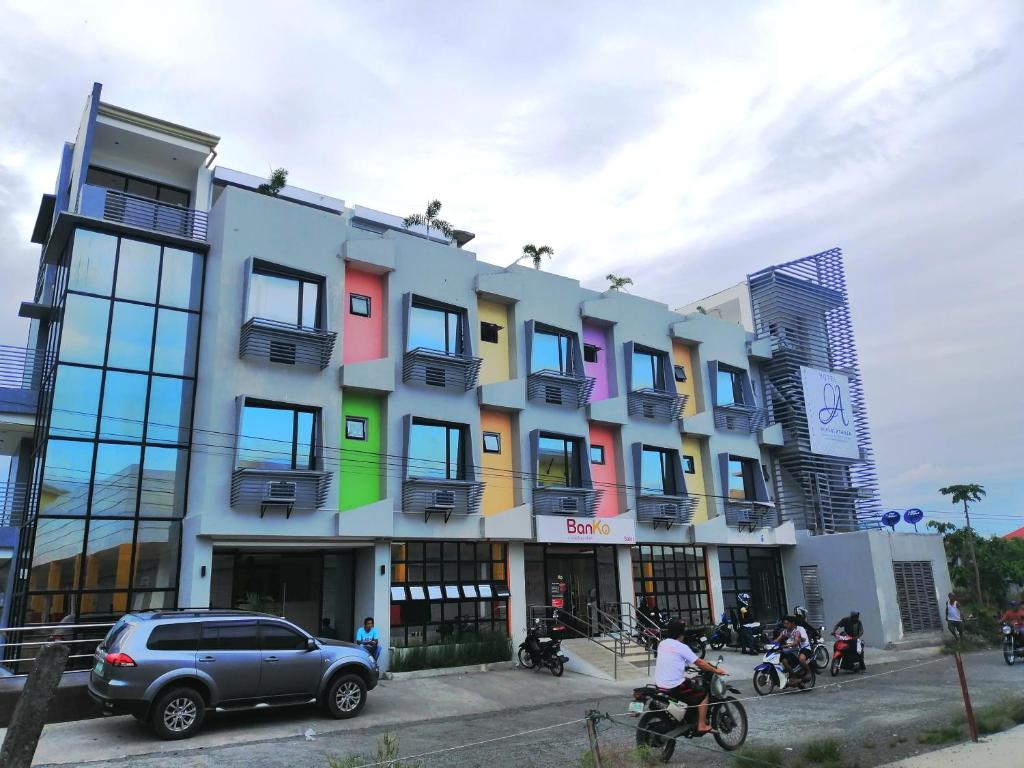 a multicolored building with cars parked in front of it at Hotel Rupert A Baler in Baler