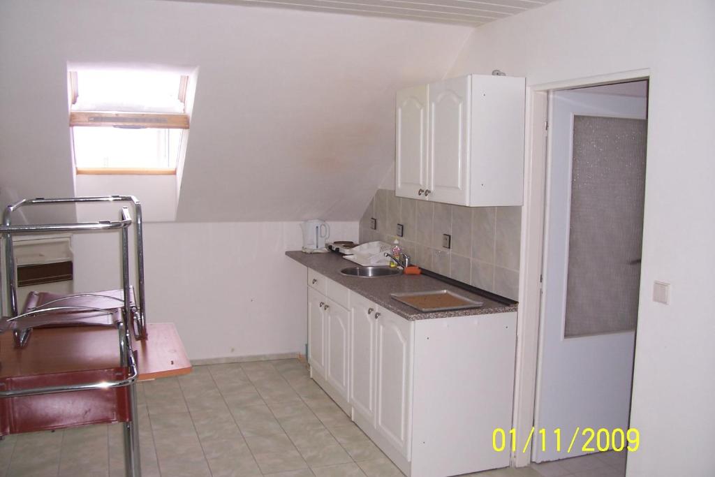 a kitchen with white cabinets and a sink at Apartmány u Jitky in Zlín