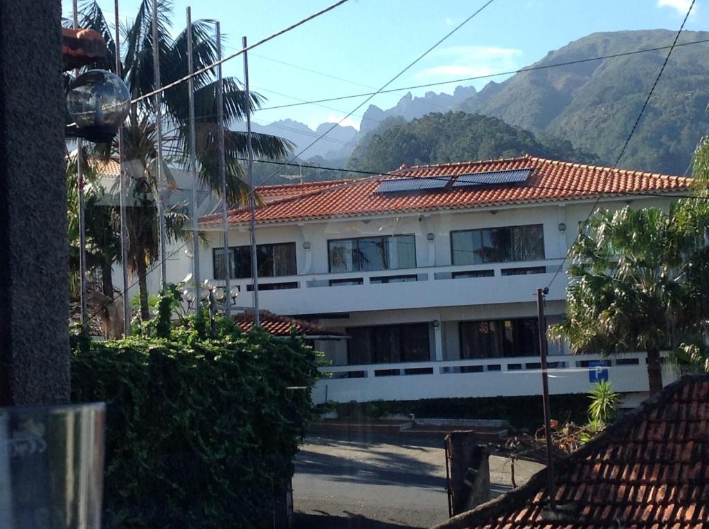 un edificio blanco con techo rojo con montañas al fondo en Rural de Sanroque, en Santana