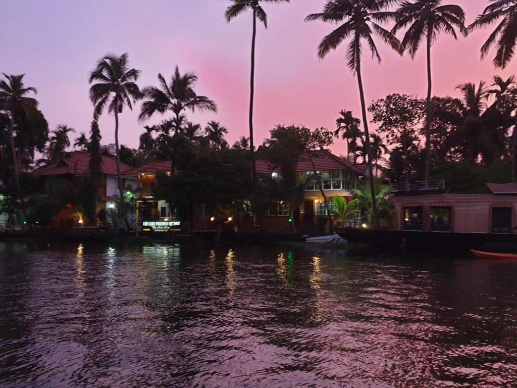a view of a river at night with palm trees at The Lake Paradise Boutique Resort in Alleppey