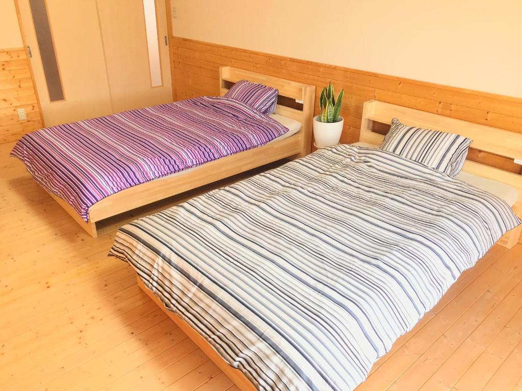 two beds sitting next to each other in a room at HIBARI GUESTHOUSE in Sendai