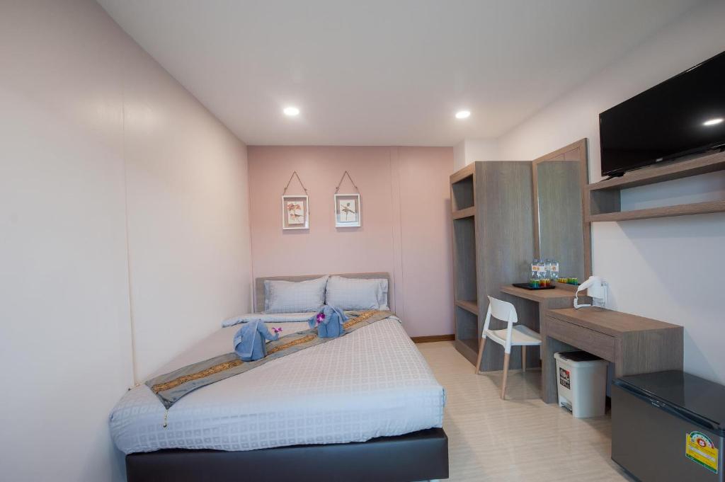 um pequeno quarto com uma cama e uma secretária em The Moon Night Hotel em Bangkok
