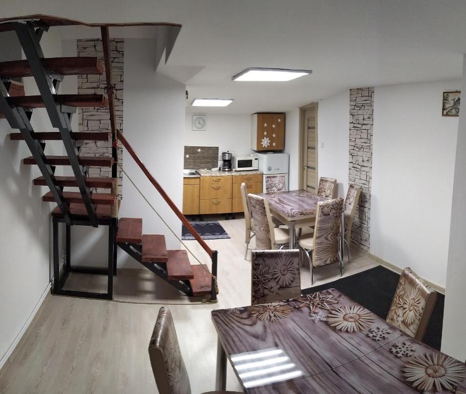 sala de estar con escalera, mesa y sillas en Casa Savianu Cavnic en Cavnic