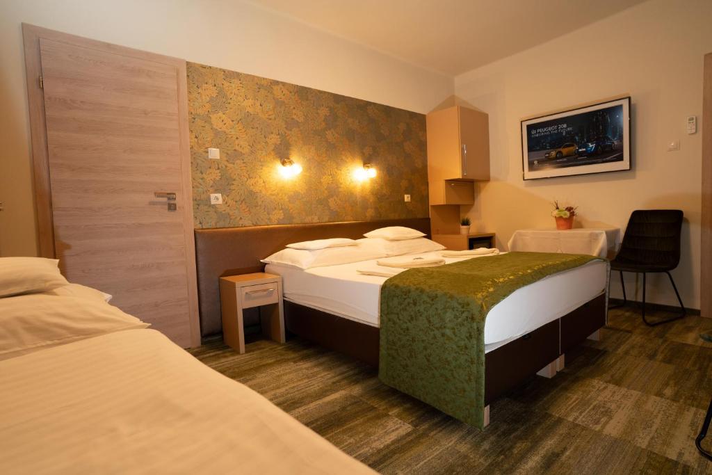 Habitación de hotel con 2 camas y mesa en Teátrum Boutique Hotel, en Győr