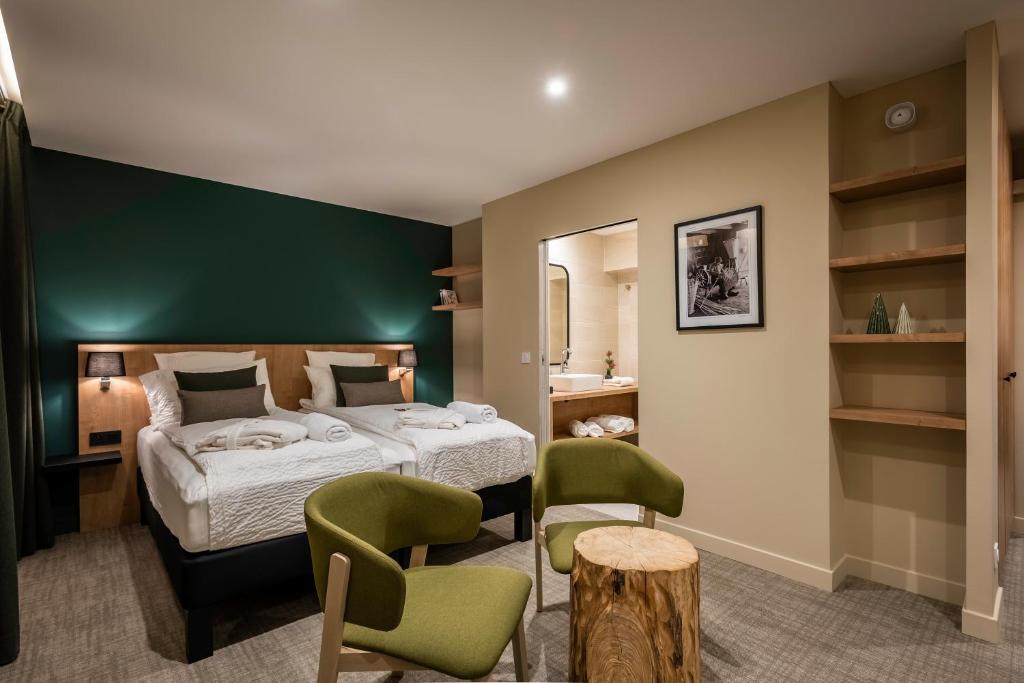 sypialnia z łóżkiem i zieloną ścianą w obiekcie La Rochette w mieście Labaroche