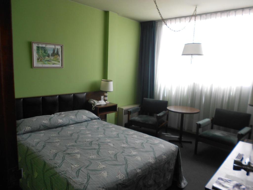 - une chambre avec un lit, deux chaises et une fenêtre dans l'établissement Eldorado, à La Paz