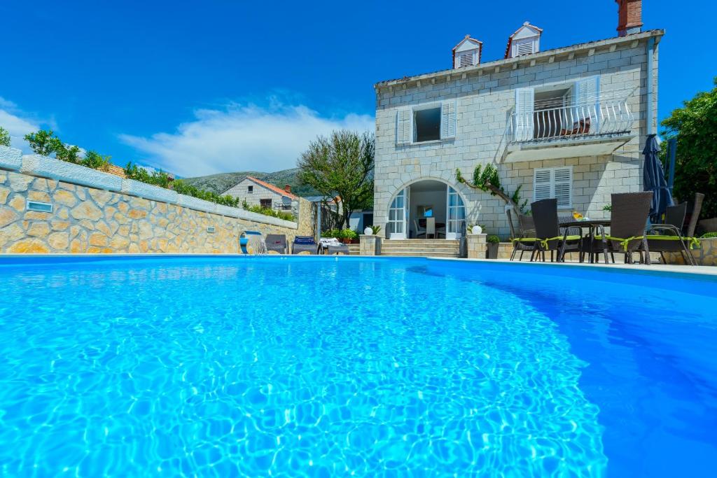 a villa with a swimming pool in front of a house at Villa Ida in Dubrovnik