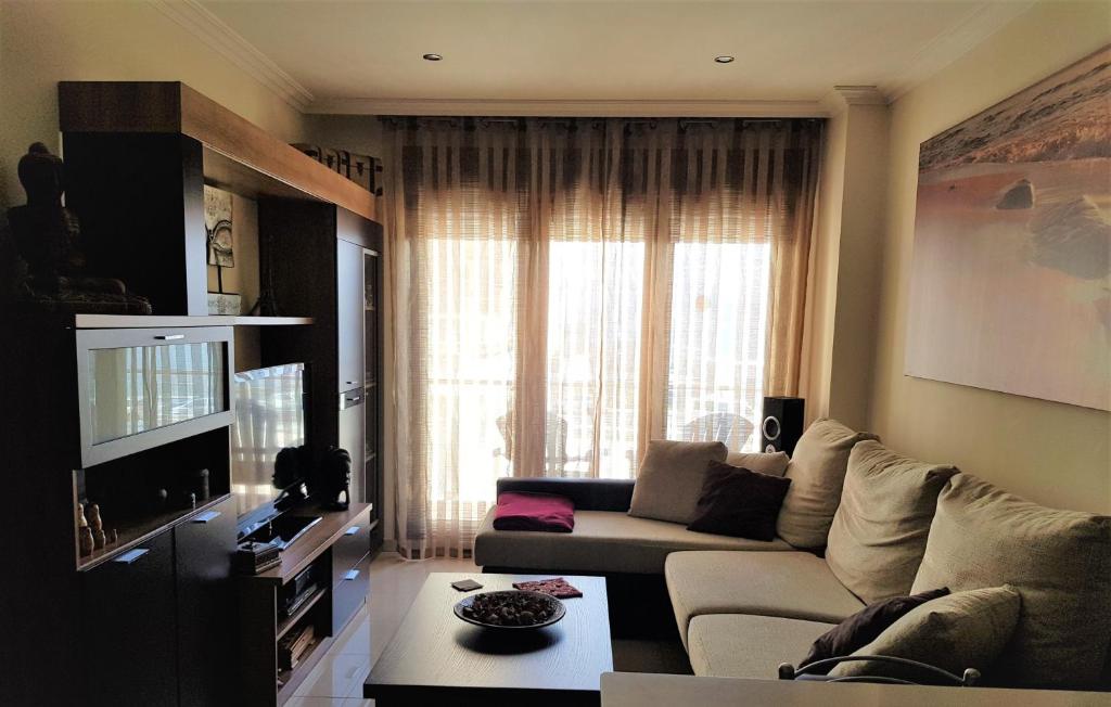 a living room with a couch and a large window at Apartamento La Cantera in Combarro