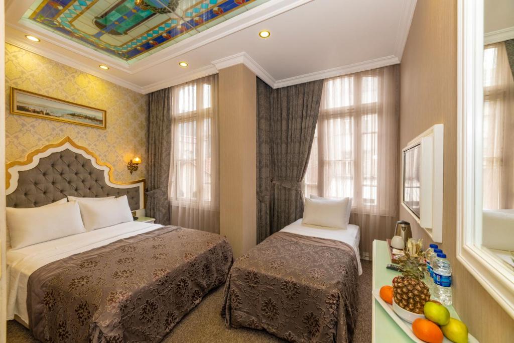 a bedroom with a bed, a dresser, and a window at Alpek Hotel in Istanbul