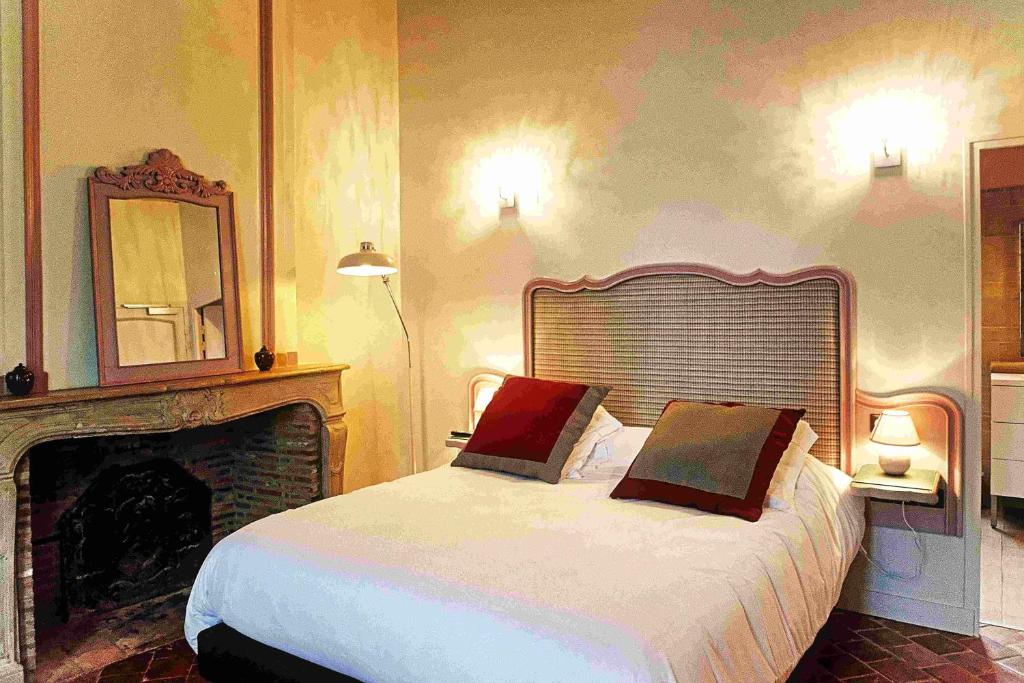 Schlafzimmer mit einem Bett, einem Kamin und einem Spiegel in der Unterkunft Logis Hôtel Le Relais Louis XI in Meung-sur-Loire