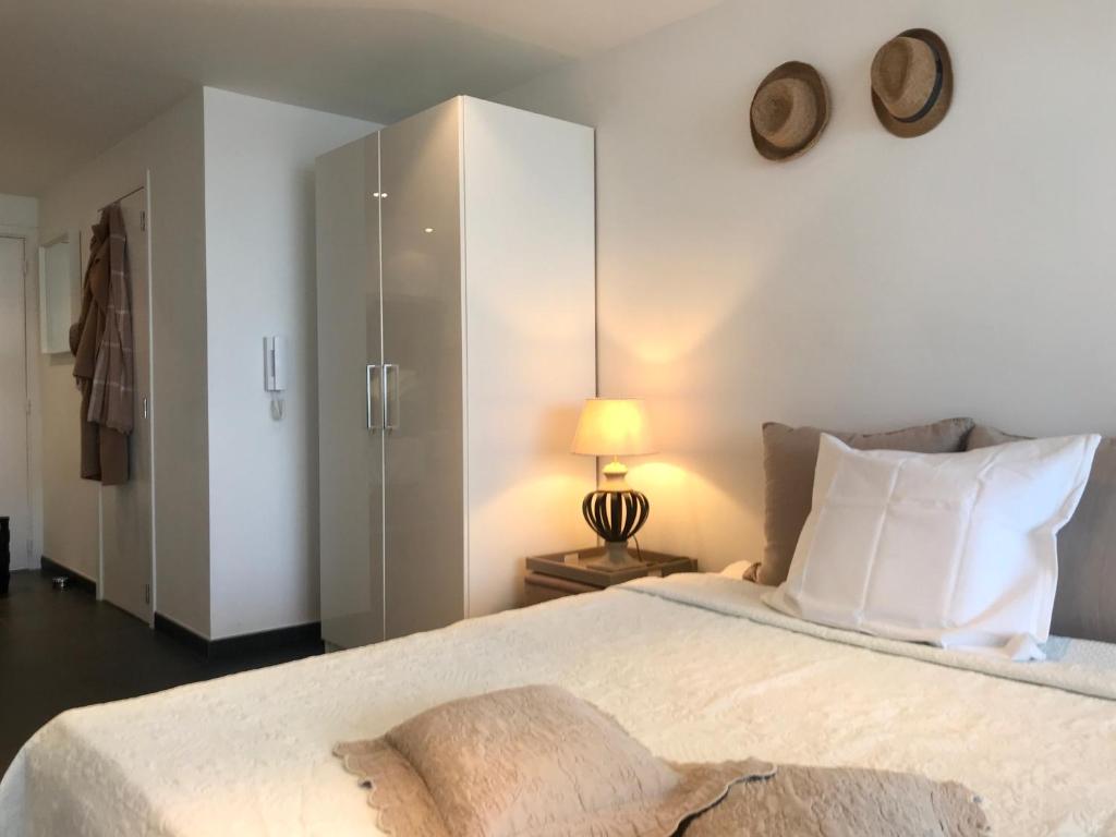 1 dormitorio con 1 cama y reloj en la pared en Sea and Dunes en Knokke-Heist