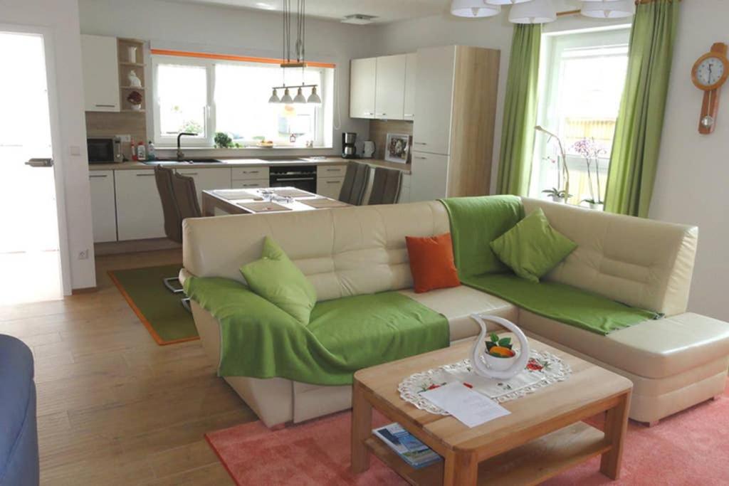 uma sala de estar com um sofá verde e uma cozinha em Top 2 Zi-Wohnung, 350 m zum See em Friedrichshafen