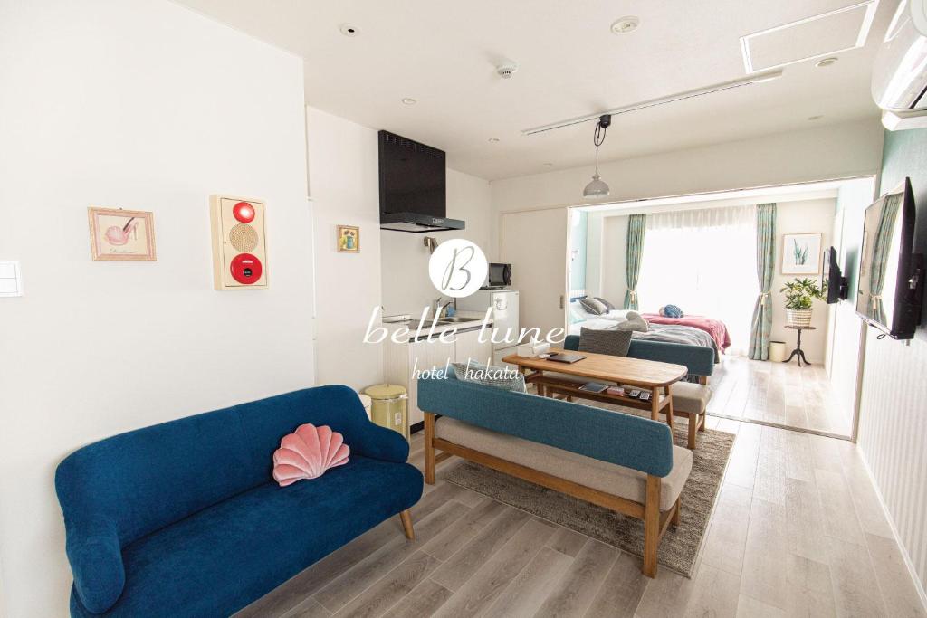 a living room with two blue chairs and a table at belle lune hotel hakata Suite Room 3 in Fukuoka