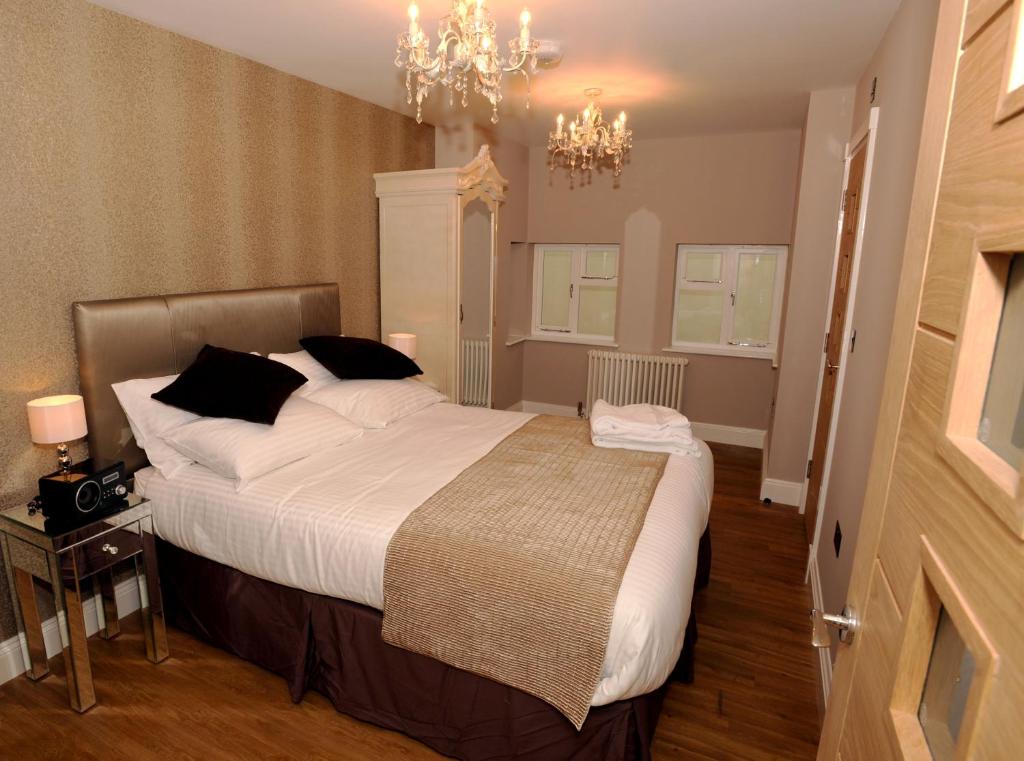 um quarto com uma cama grande e um lustre em Tower Apartments em Southend-on-Sea