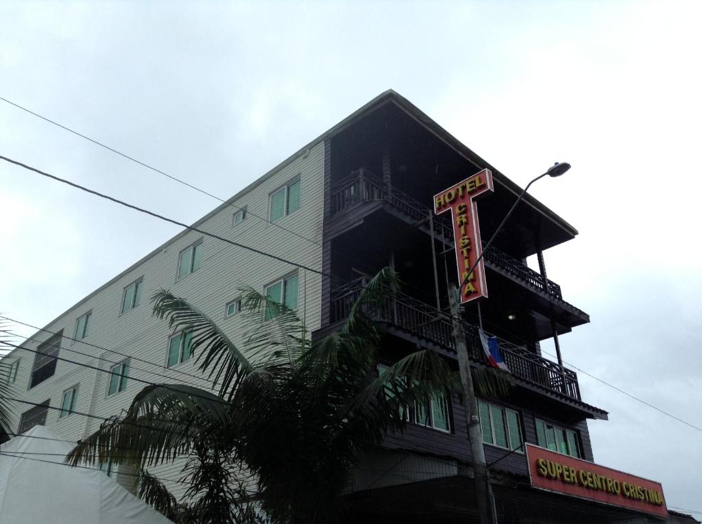 un grand bâtiment avec un panneau devant lui dans l'établissement Hotel Cristina, à Bocas del Toro