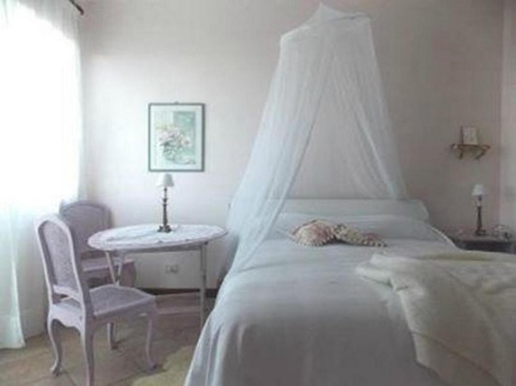 BaiardoにあるB&B Le Camelie del Boscoのベッドルーム1室(ベッド1台、テーブル、椅子付)