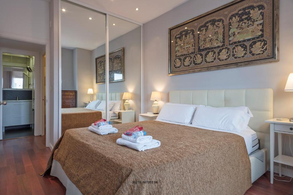 a bedroom with a large bed with towels on it at Alcam Augusta in Barcelona