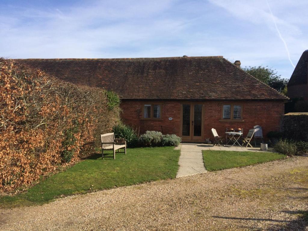 uma casa de tijolos com uma mesa e cadeiras em frente em Starvegoose Cottage em Goudhurst