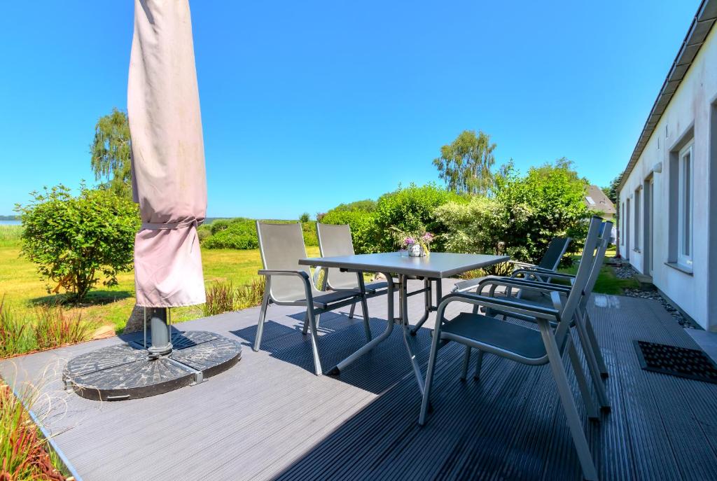 a patio with a table and chairs on a deck at Appartementhaus am Schmollensee mit Seeblick in Heringsdorf