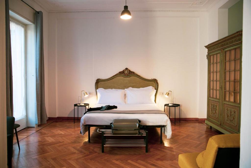 een slaapkamer met een groot bed en een houten vloer bij Palazzo Pasta Malpensa in Gallarate