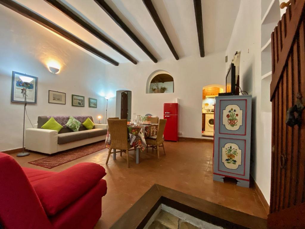 een woonkamer met een rode bank en een tafel bij Holidaycasa Martina - Nel cuore del Centro Storico in Sperlonga
