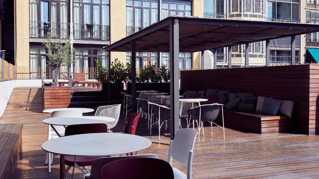 a patio with tables and chairs on a building at TOC Hostel Barcelona in Barcelona