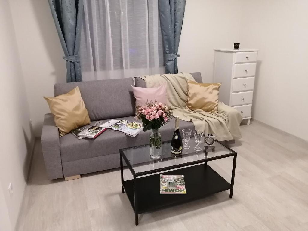 a living room with a couch and a table with flowers at Prima Family Apartments in Prague
