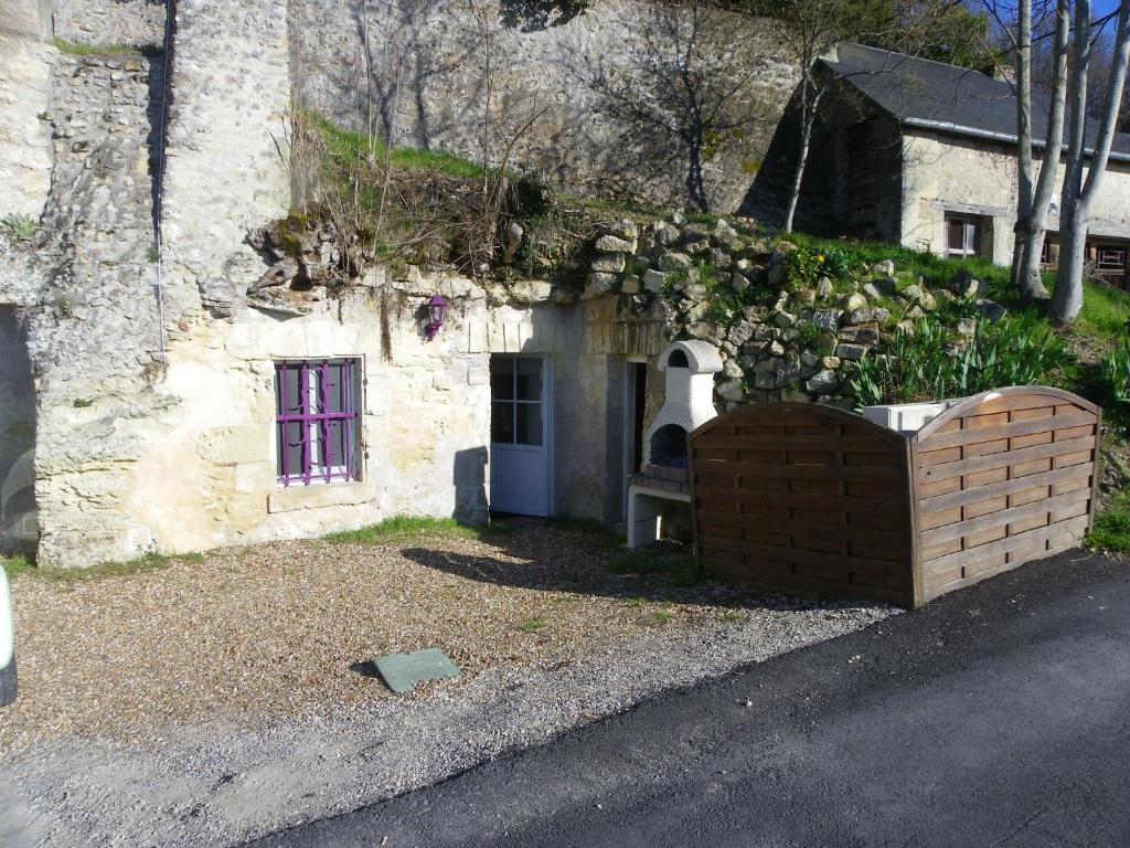 ein altes Steingebäude mit einer Steinmauer und einer Tür in der Unterkunft Les Hauts de Nazelles in Nazelles