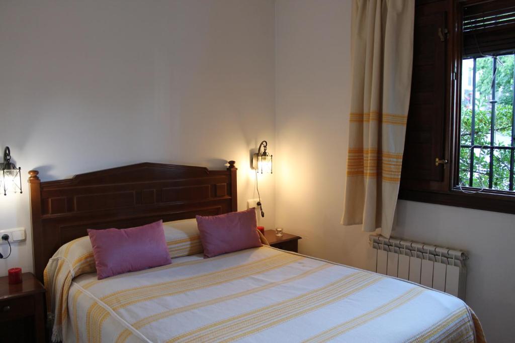 sypialnia z łóżkiem z 2 fioletowymi poduszkami w obiekcie Apartamentos Rurales Rosendo: La Canela w mieście Capileira
